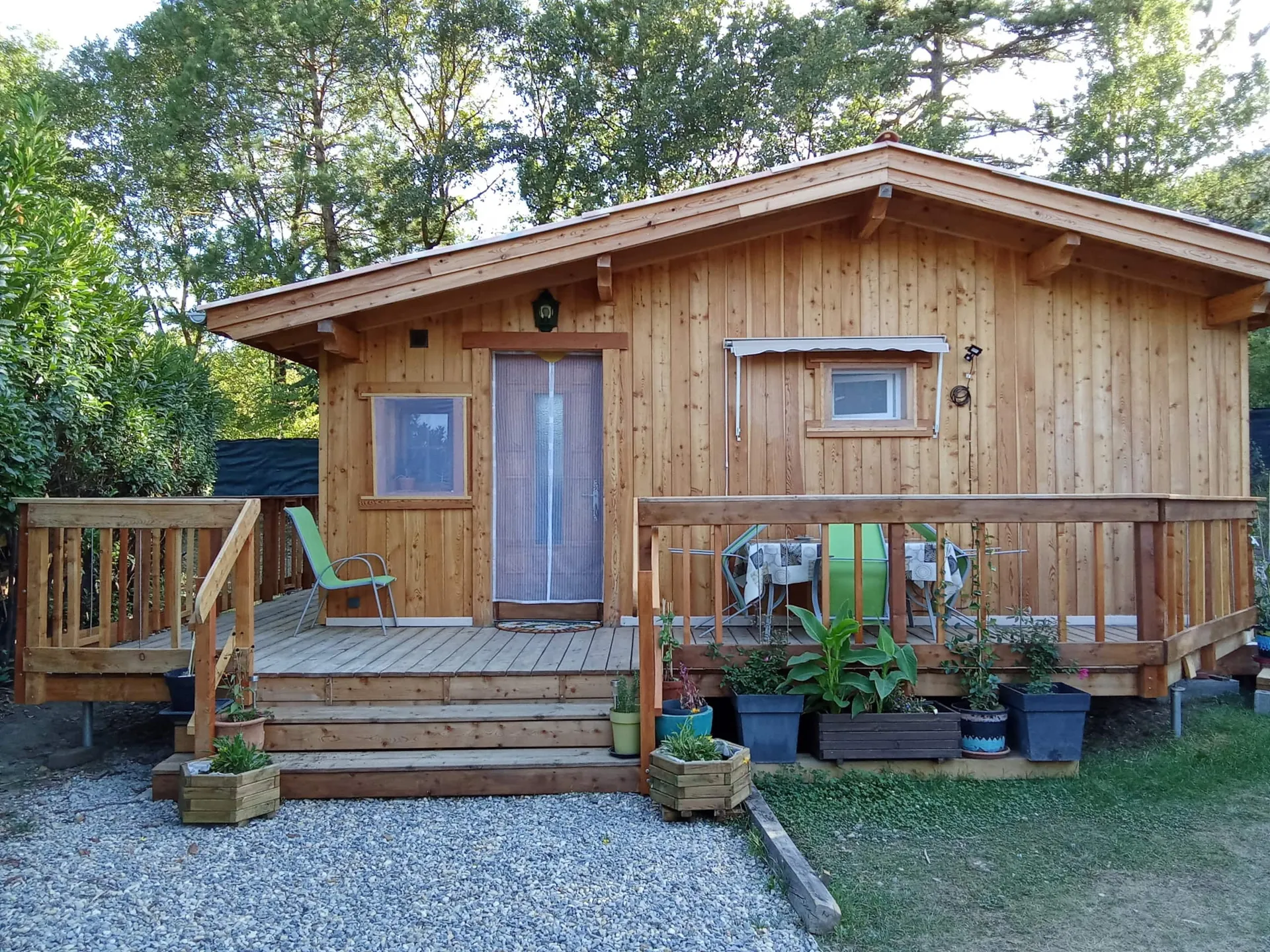 Le chalet de face, l’escalier de la terrasse et l’allée de gravier