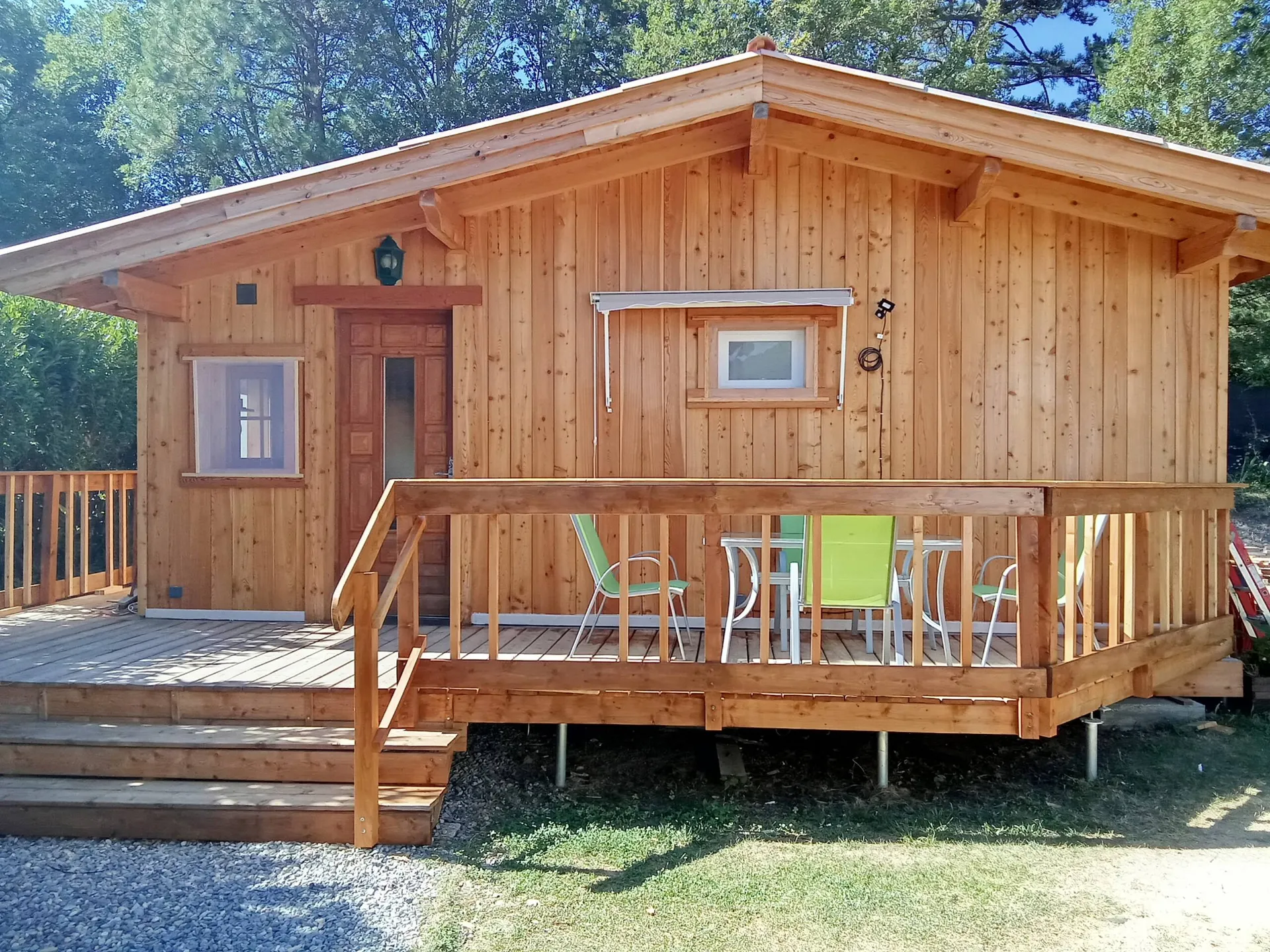 Le chalet en mélèze et sa grande terrasse, au soleil du matin