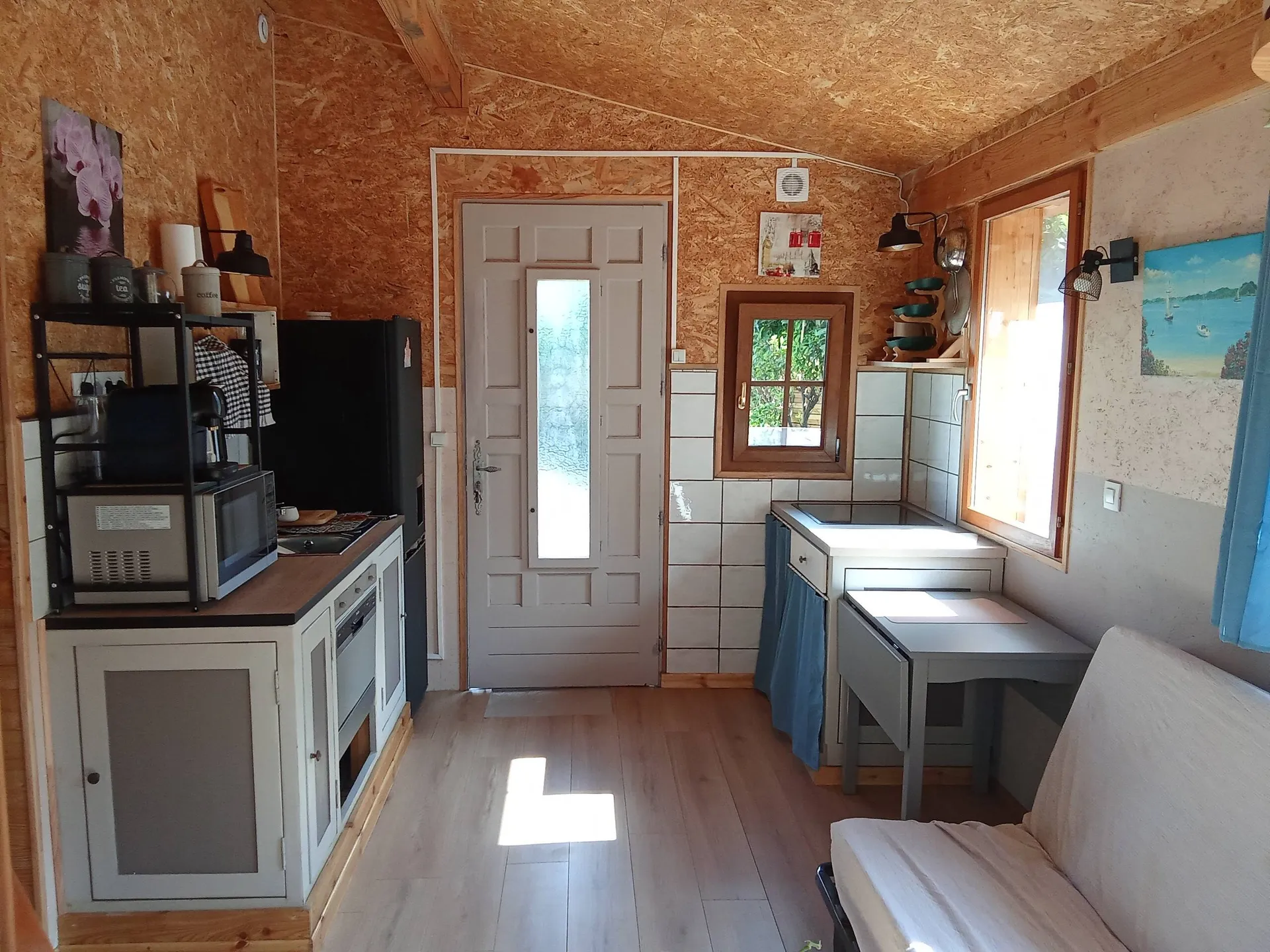 La cuisine équipée et la porte d’entrée vitrée