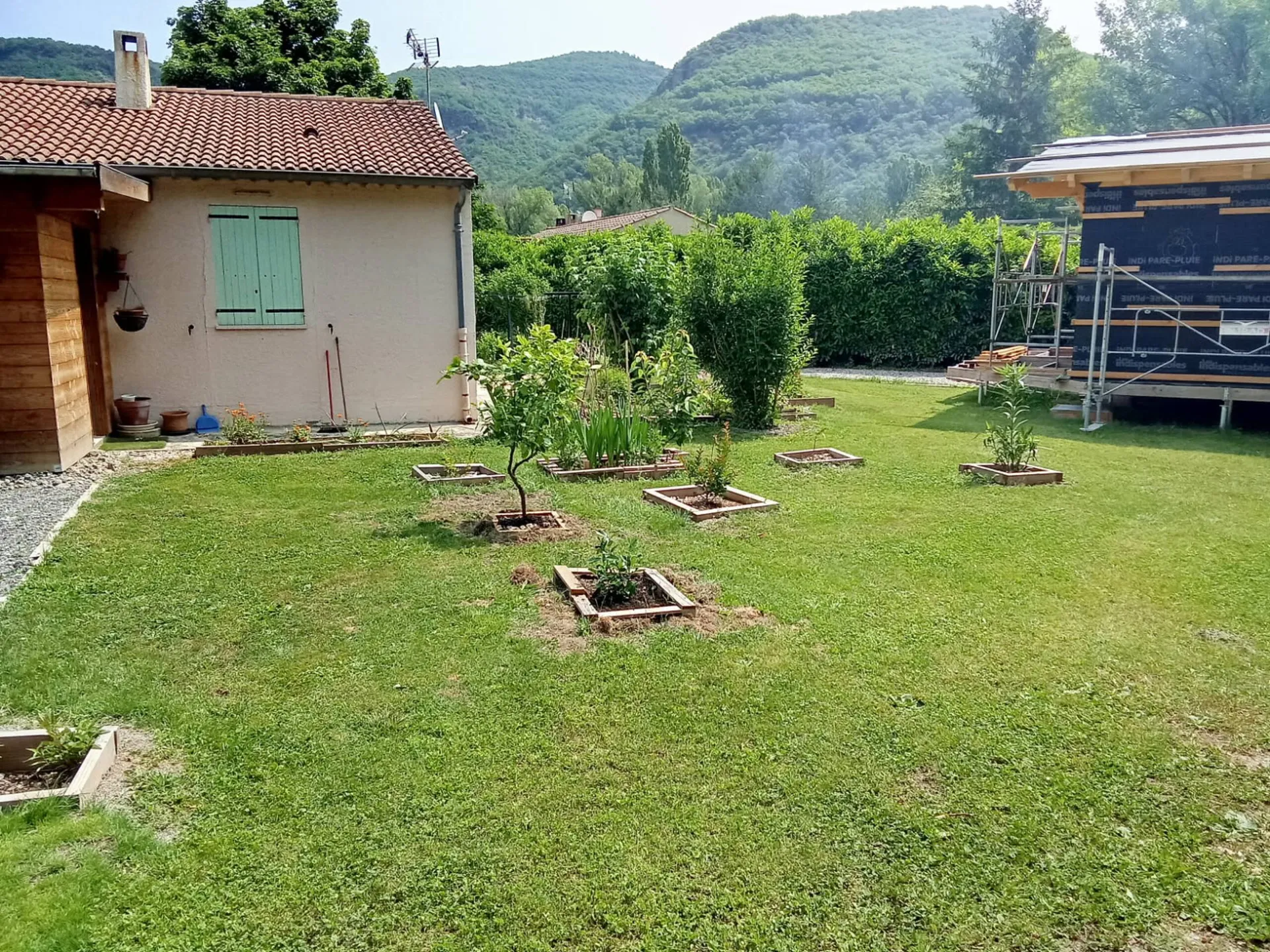 La pelouse et ses jeunes arbres fruitiers, les collines en fond