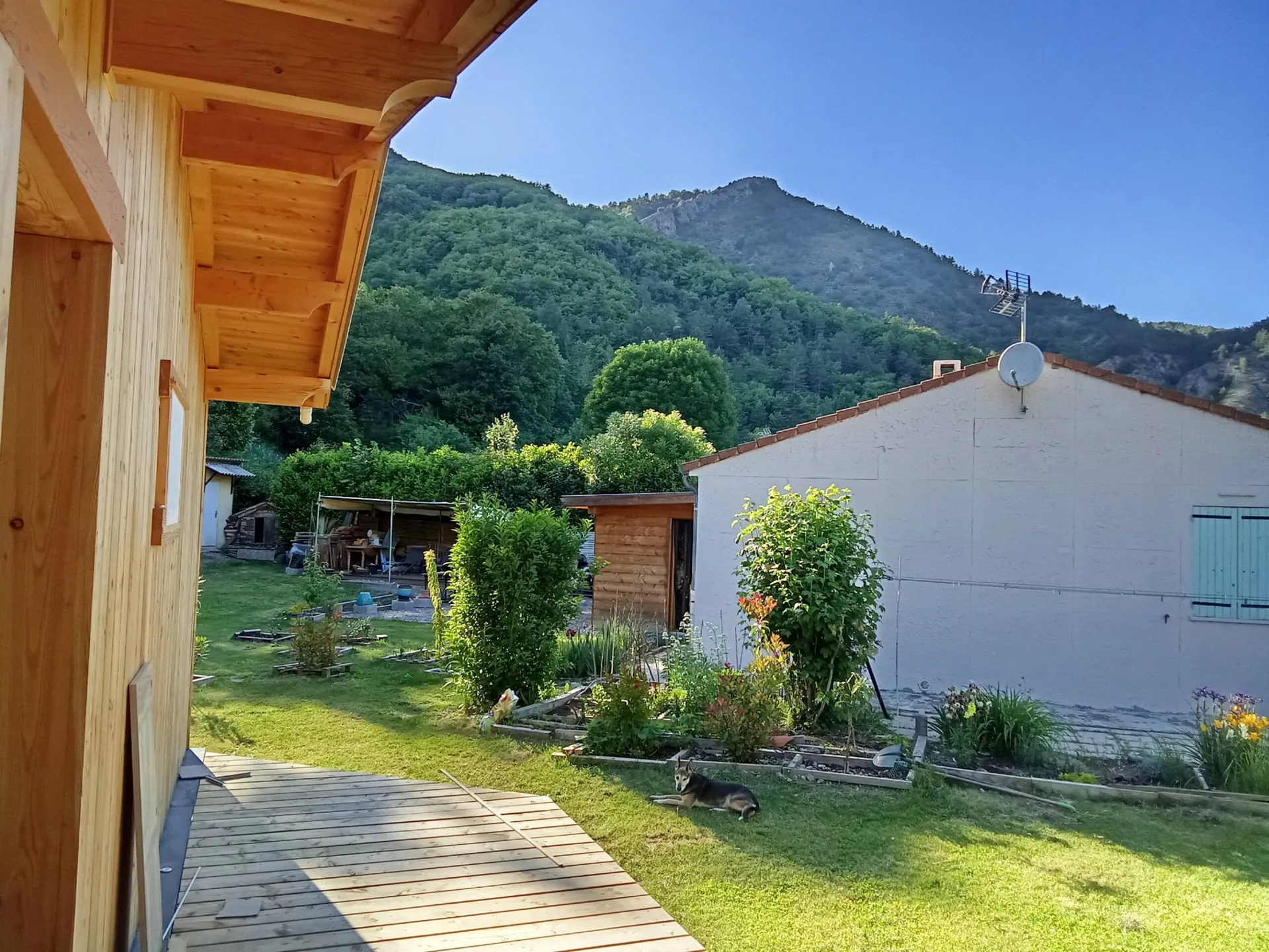 Le jardin du chalet ouvert sur la montagne boisée