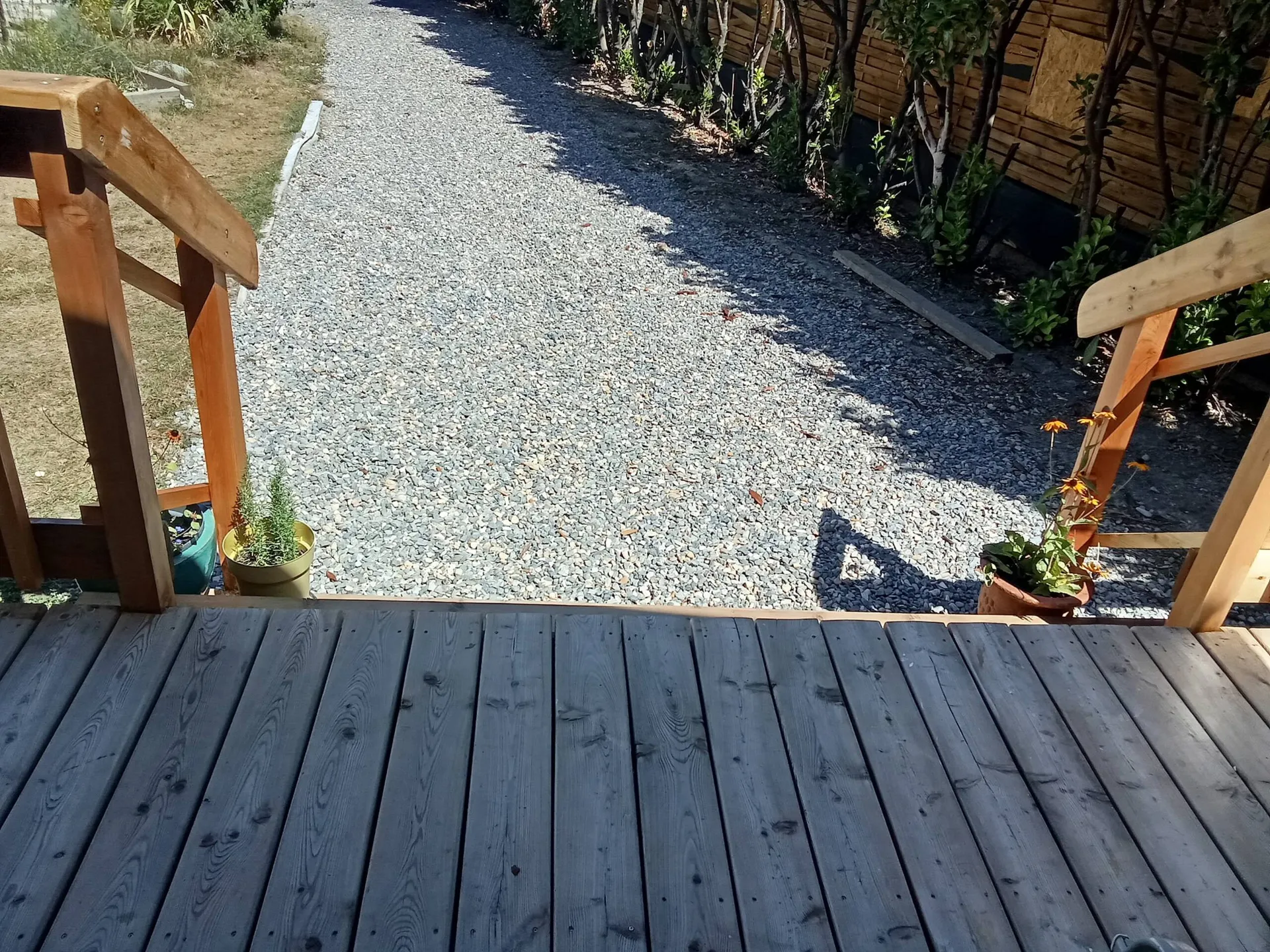 Le plancher de la terrasse et l’allée de gravier en contrebas