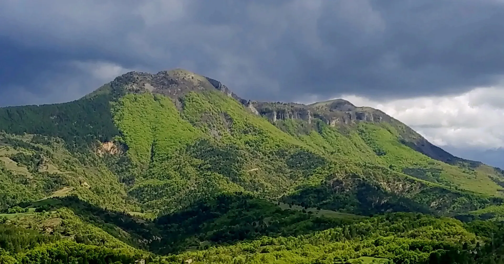 Le Cousson, sommet boisé des Préalpes de Digne sous un ciel d’orage