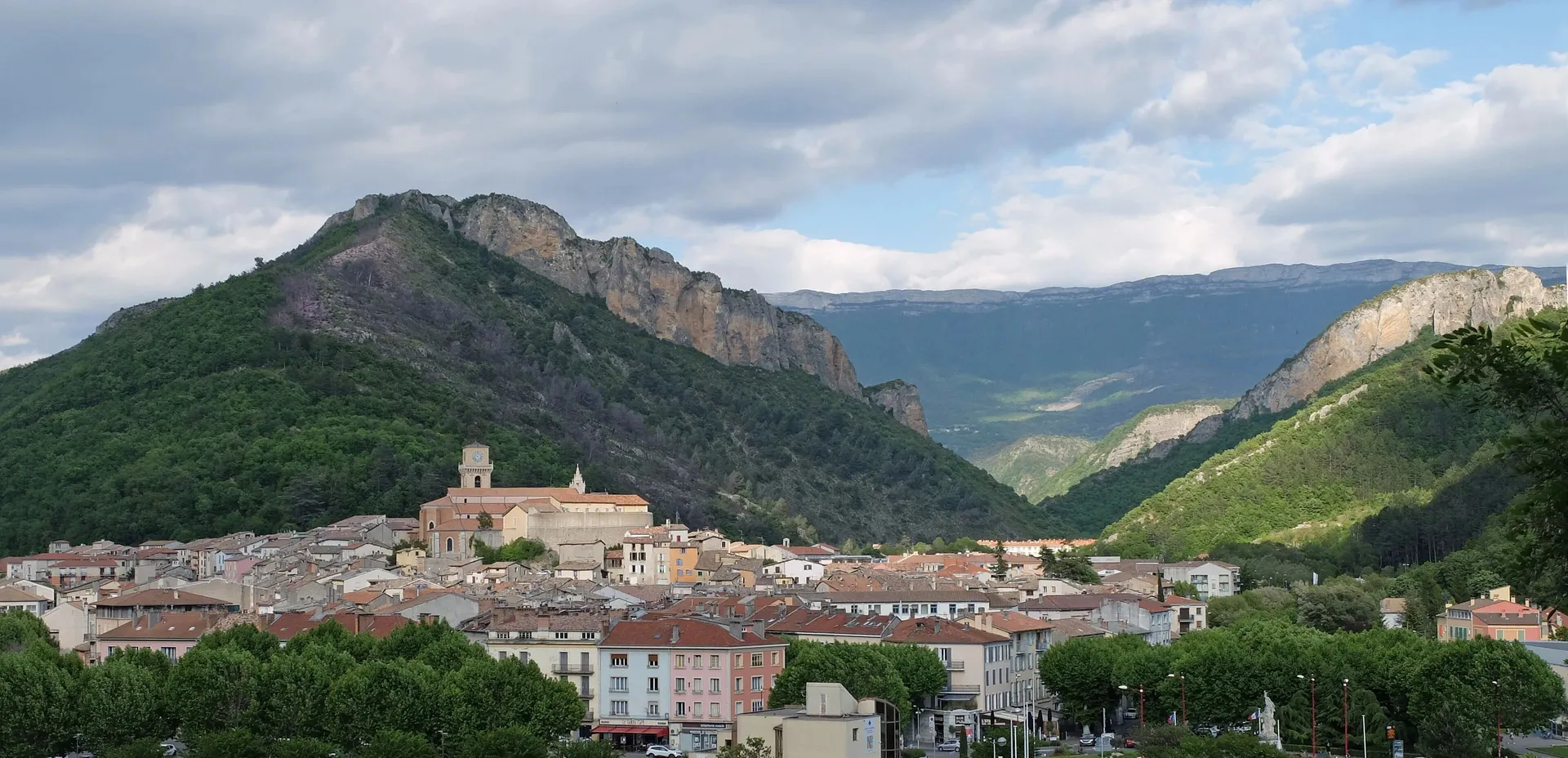 Digne-les-Bains au pied du Rocher de Neuf-Heures, les montagnes boisées tout autour